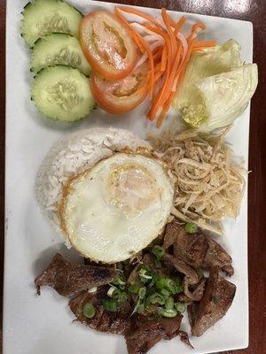 Com Bi Thit Nuong Cha (Grilled Pork) with sliced pork skin, white rice and egg.