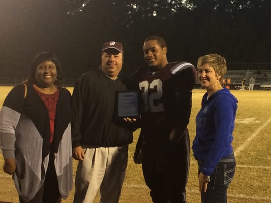 A.P. and Jennifer present the Allstate Good Hands award to Prince, an outstanding student athlete at WHS.