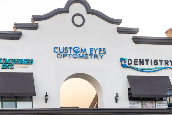 Exterior view of a shopping plaza housing Custom Eyes Optometry, Costa Mesa, CA.