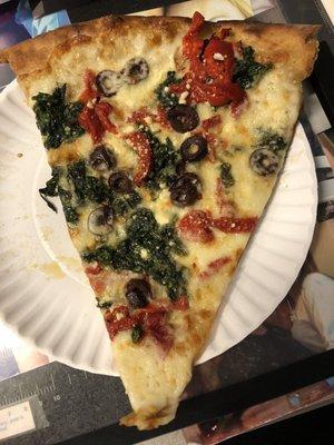 White pizza with spinach, roasted peppers and black olives.