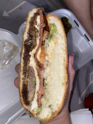 Torta cubana. Avocado, tomato, hot link, Oxacan cheese, and hand breaded beef steak.