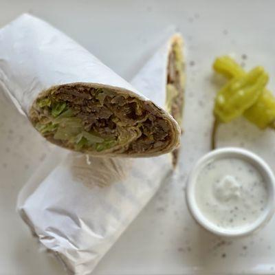 Lamb Beef Gyros Wrap Marinated lamb and beef, slow-cooked and thinly sliced. with Salad, Hummus & Sauce Inside.