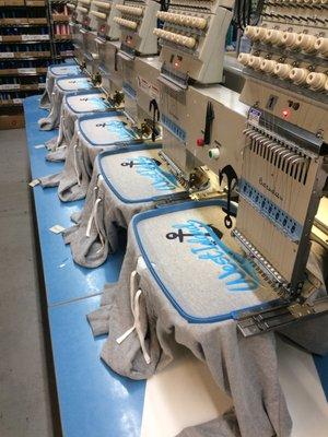 One of our 6 head stretch embroidery machine that can run larger custom applique sweat shirt or full Jacket back logos.