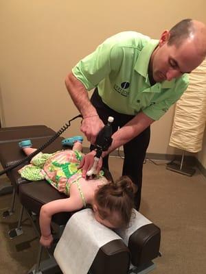 Dr. Stelios adjusting a pediatric patient using the ArthroStim device