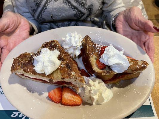 Annette is enjoying her strawberry  stuffed French toast with coffee