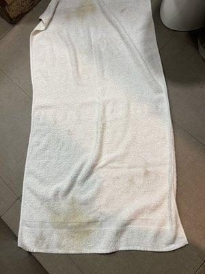 Only towel in room with yellow stains