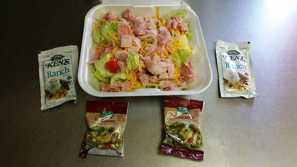 Chef salad - lettuce, tomato, cheddar cheese, turkey, ham, and croutons. 2 packets of dressing included.