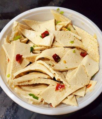 Sliced Tofu cold appetizer. Tender tofu, with scallion, chilis, and cilantro. Tasty mild flavor.