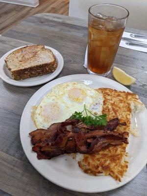 Bacon and eggs over medium, has browns, wheat toast, and iced tea. Great breakfast.