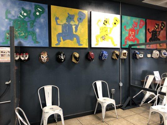 Waiting area featuring masks and wall artwork.