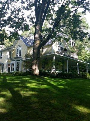 the main house with a good view of the wraparound porch that has numerous chairs where you can relax.