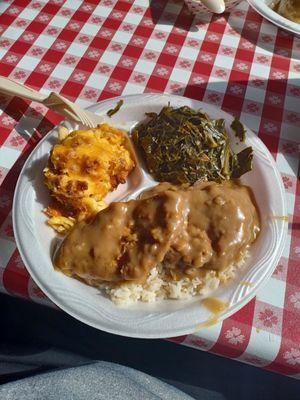 Smothered pork chops, color greens, rice and macaroni and cheese.