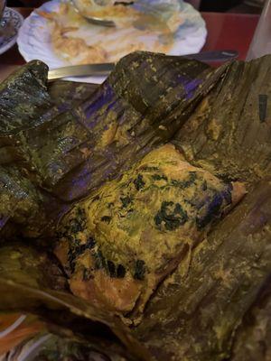 BBQ steamed salmon in banana leaf. The fresh herbs mixed in create a delicious flavor.