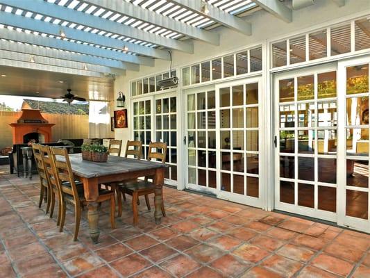 Sliding french doors and with eyebrow accent windows separate cathedral ceiling family room and spanish tiled covered lanai.