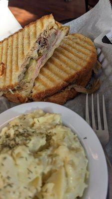 Cuban panini with a side of potato salad.