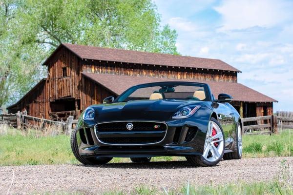 A Jaguar F-Type with a barn in Boulder county