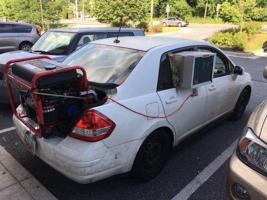 Car with generator operating air conditioner placed in car window.... sitting near the door of this store most days