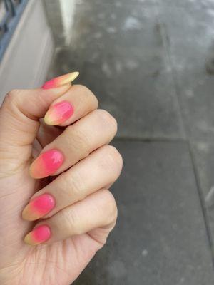 Dip nail manicure with a pink and yellow gradient/ombre design.