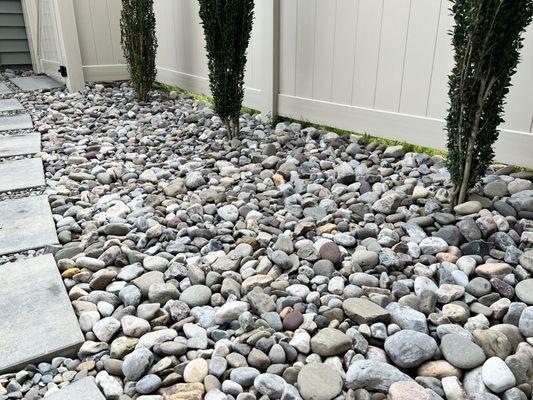 Ocean of huge rocks that are hard to walk across to water the plants or to access the patio.