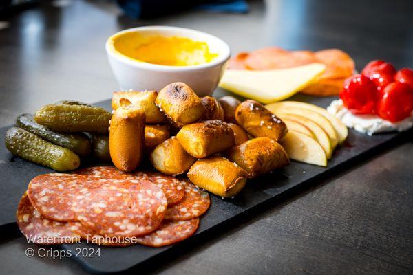 Waterfront Pub
 Soft pretzel, Tillamook white cheddar, pickles, peppadew peppers, soppressata salami, pepperoni, stone ground mustard.