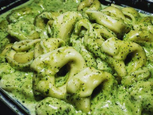 Tortellini stuffed with cheese deliciously drowning in pesto sauce