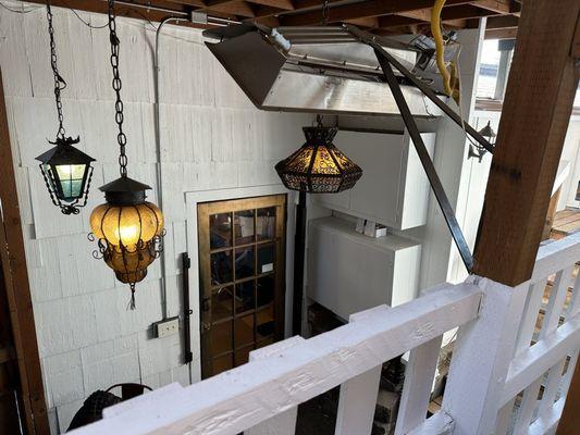 View from back patio seating down to the rear door of the house, leading to the bar and inside dining area.