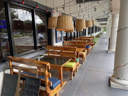 Outdoor tables near the front entrance. There's also a covered patio with more seating.