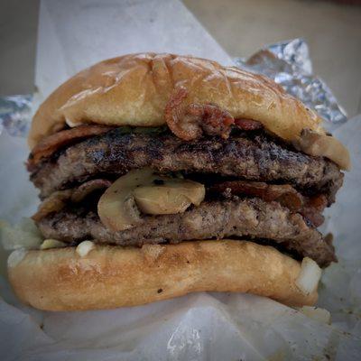 Double meat burger with bacon, mushrooms, pickles and onions.