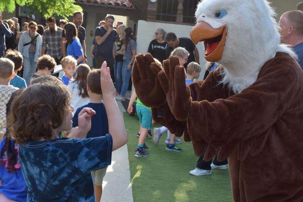 Everest the Eagle high-fives a brand new kindergartener, Class of 2030!