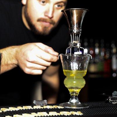 Absinthe Minded GOLD being served in a see-saw dripper in the traditional fashion.  Note: the beginning of the "louche" phenomenon