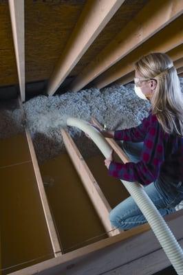 Insulation is installed on the floor of an attic.