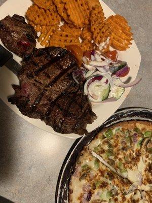 Ribeye with bomb sweet potatoes waffle fries and vegetarian white sauce cauliflower pizza.