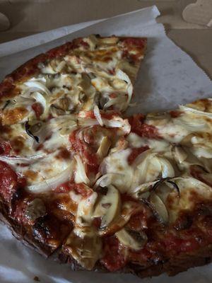 Cauliflower crust pizza with onions and mushrooms.