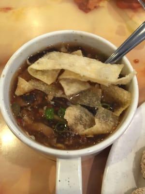 Hot & sour soup with wonton and spring onions.