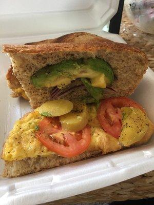 Egg sandwich with tomato and avocado and potatoes