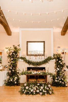 Sweetheart table, fireplace mantle, repurposed ceremony arches