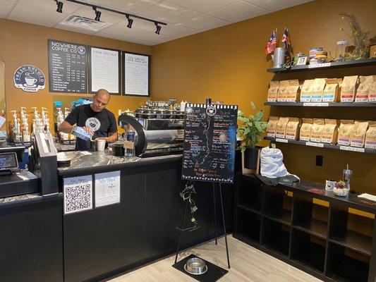 Counter with whole bean coffee for sale along with a variety of traditional and specialty drinks.