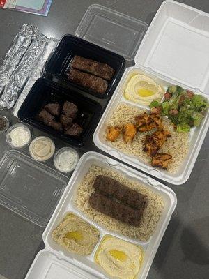 Shish tawook plate on rice, fatoush and hummus, kafta plate, baba ghanouj, a lamb kafta skewer, beef cube skewer