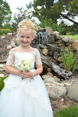 Wedding Flower Girl posing for picture by mini waterfall