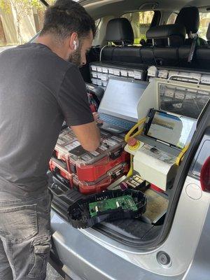 Here's the technician with my display taken apart (bottom right corner). He used a screwdriver to open it.