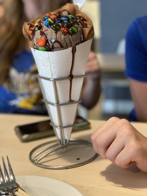 Bubble waffle ice cream cone with chocolate ice cream and mnm's.