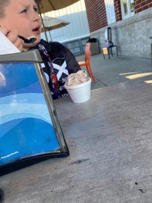 Enjoying his Oreo ice cream in a cup