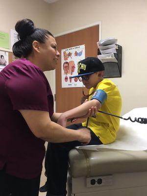 Hes listening to his heart beat while she explains what he's hearing.