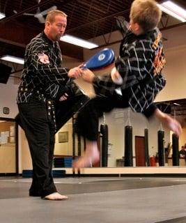 Master Konley drilling kicks with his son, Zach.