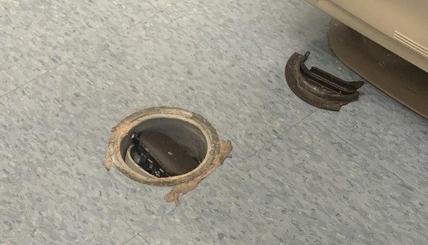 The hole in the floor underneath the examination table.