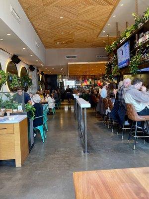 View of inside of restaurant from front looking back. Super cute, very clean, fun + happenin' place with big bar area up front.