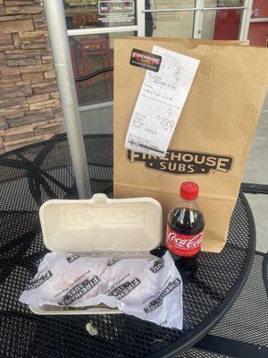 Nice sandwich wrapped in their logo wax paper and to-go box. Goes perfectly with the bottle of soda coca-cola!