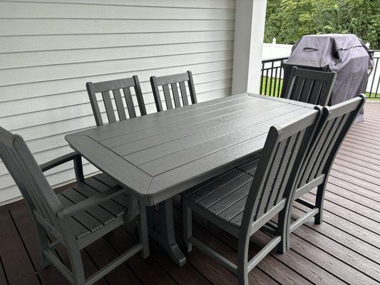 Polywood dining table and seating for 6. Two chairs with arms and four chairs armless.