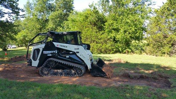 Clear Land skid steer doing bucket work.