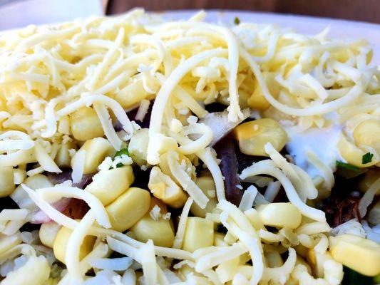 Corn, barbacoa, sour cream, cheese, green salsa, pinto beans